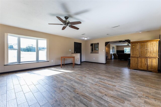 unfurnished living room with dark wood-type flooring and ceiling fan