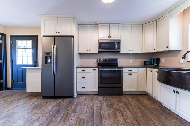 kitchen featuring dark wood-type flooring, white cabinetry, and stainless steel appliances