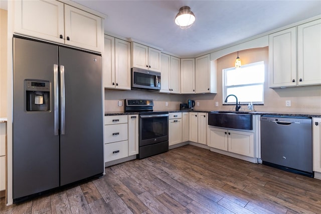 kitchen featuring appliances with stainless steel finishes, dark hardwood / wood-style floors, sink, and white cabinetry