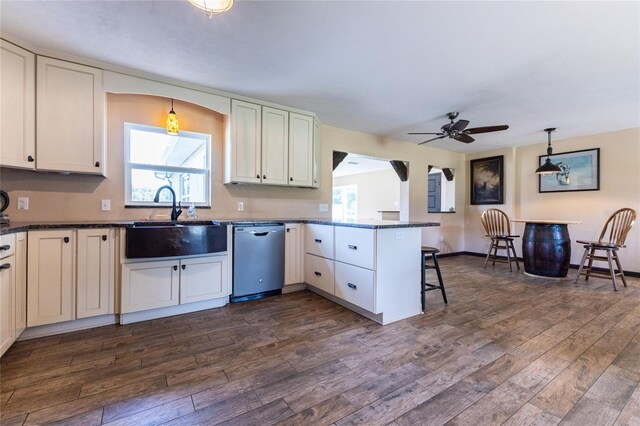 kitchen with dishwasher, kitchen peninsula, sink, pendant lighting, and dark hardwood / wood-style flooring