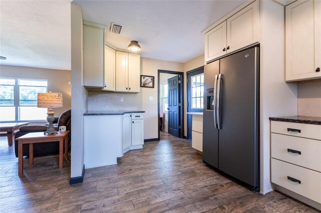 kitchen featuring stainless steel fridge, white cabinets, and dark hardwood / wood-style floors