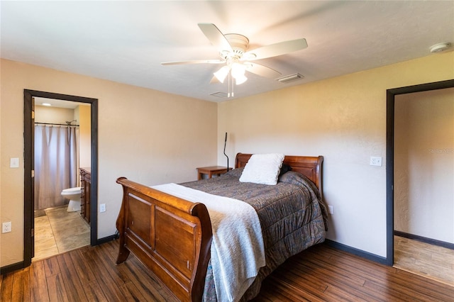 bedroom with ensuite bath, dark hardwood / wood-style floors, and ceiling fan