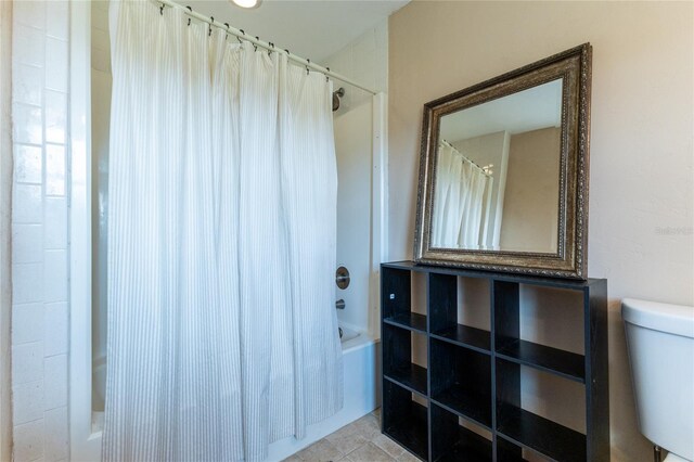 bathroom with toilet, tile patterned floors, and shower / tub combo