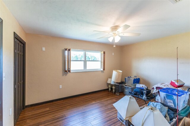 interior space with dark wood-type flooring and ceiling fan