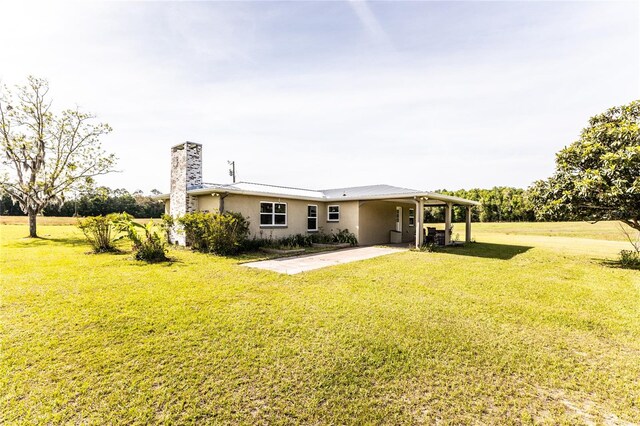 rear view of property featuring a lawn