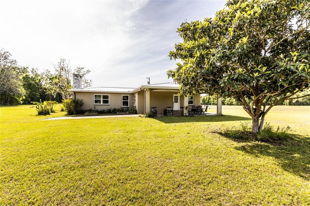 back of property featuring a yard