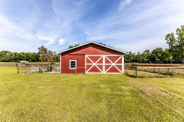 view of outdoor structure featuring a lawn and a rural view