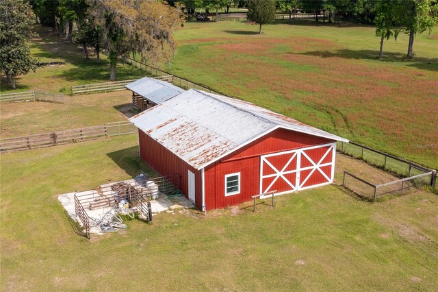 view of outdoor structure featuring a lawn and a rural view