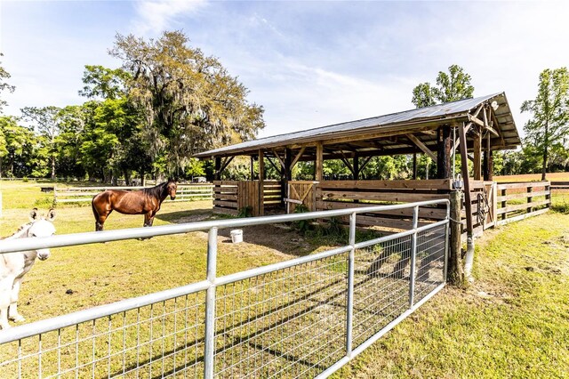 view of horse barn featuring a rural view