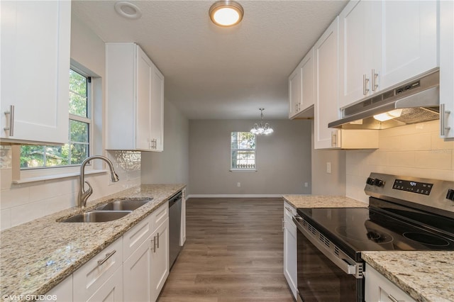 kitchen featuring white cabinetry, stainless steel appliances, sink, and decorative light fixtures