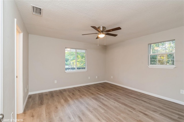 empty room with light hardwood / wood-style flooring, a textured ceiling, and ceiling fan