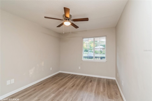 spare room featuring a textured ceiling, light hardwood / wood-style floors, and ceiling fan