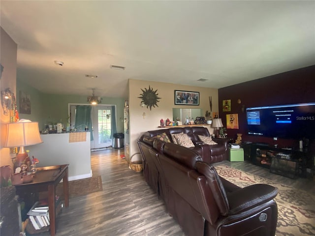 living room with an inviting chandelier and hardwood / wood-style flooring