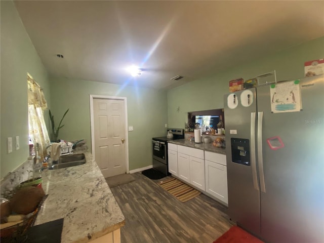 kitchen with appliances with stainless steel finishes, dark hardwood / wood-style flooring, light stone countertops, sink, and white cabinets