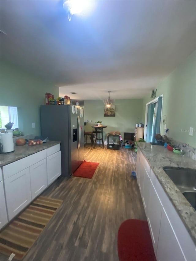 kitchen featuring stainless steel fridge, dark hardwood / wood-style flooring, light stone countertops, sink, and white cabinets