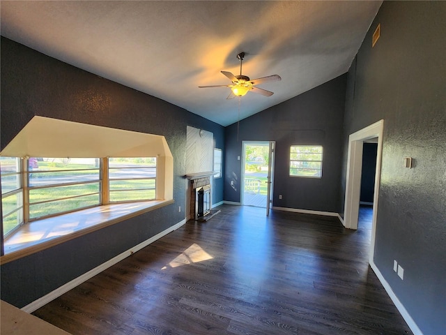 unfurnished living room featuring lofted ceiling, dark hardwood / wood-style floors, a tile fireplace, and ceiling fan