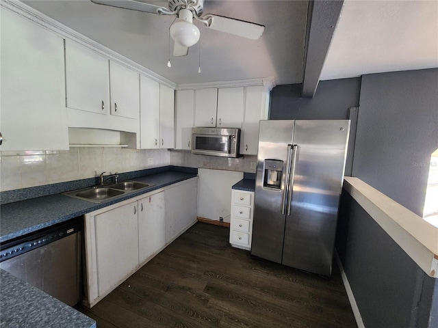 kitchen with beam ceiling, stainless steel appliances, sink, white cabinets, and dark hardwood / wood-style flooring