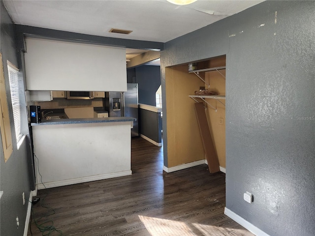 kitchen featuring appliances with stainless steel finishes, kitchen peninsula, dark hardwood / wood-style floors, and sink