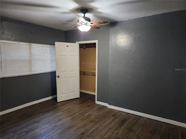 unfurnished bedroom with dark hardwood / wood-style floors, a closet, and ceiling fan