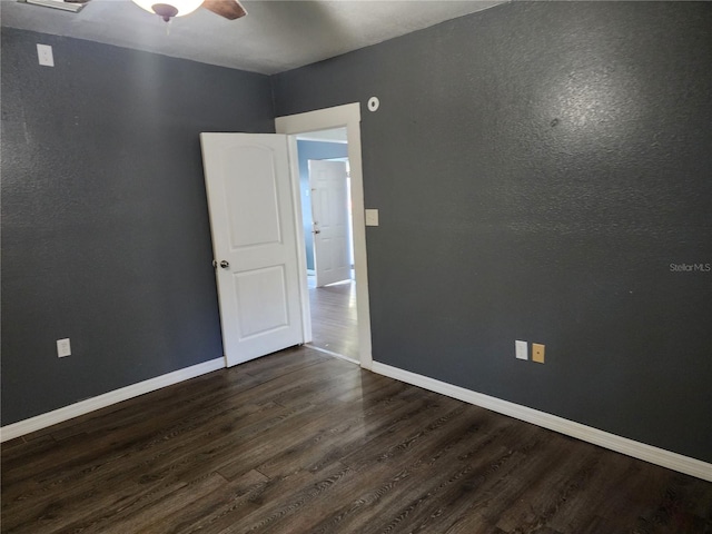 unfurnished room with ceiling fan and dark hardwood / wood-style floors