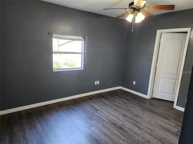 empty room with ceiling fan and dark hardwood / wood-style flooring