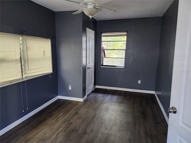 unfurnished room featuring dark wood-type flooring and ceiling fan