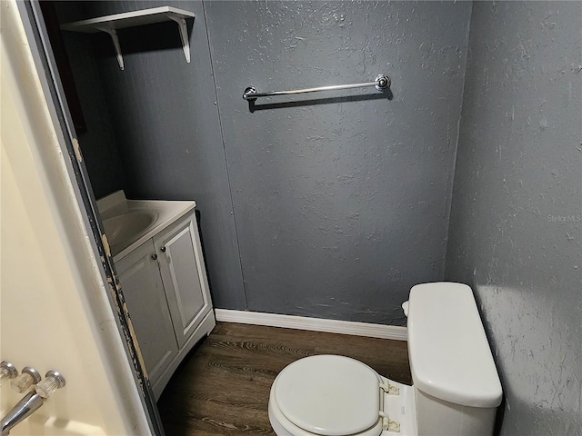 bathroom with vanity, toilet, and wood-type flooring