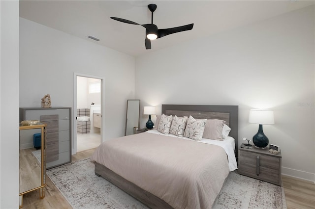 bedroom with connected bathroom, light hardwood / wood-style floors, and ceiling fan