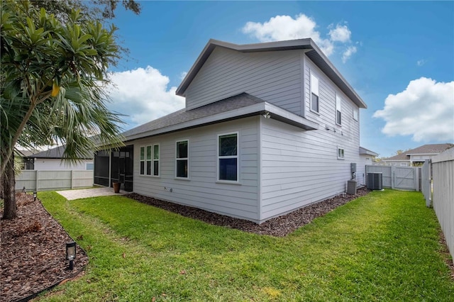 view of side of home with a sunroom, cooling unit, and a yard