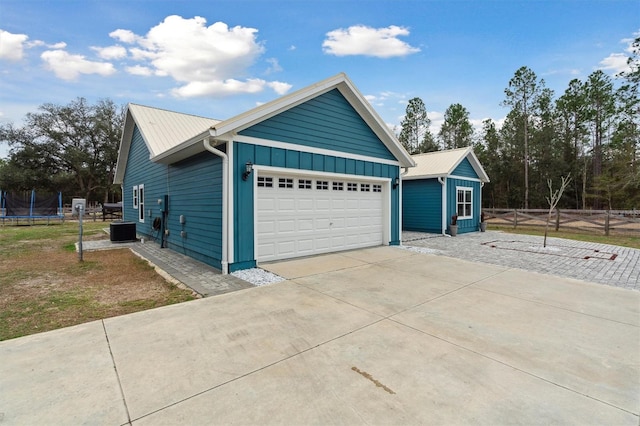 view of home's exterior with central AC, a garage, and a trampoline