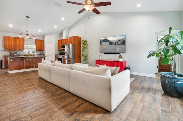 living room featuring sink, dark hardwood / wood-style floors, high vaulted ceiling, and ceiling fan