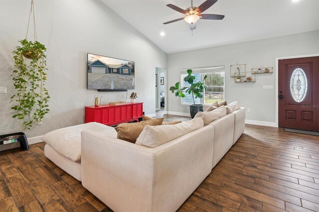 living room with dark wood-type flooring, ceiling fan, and high vaulted ceiling