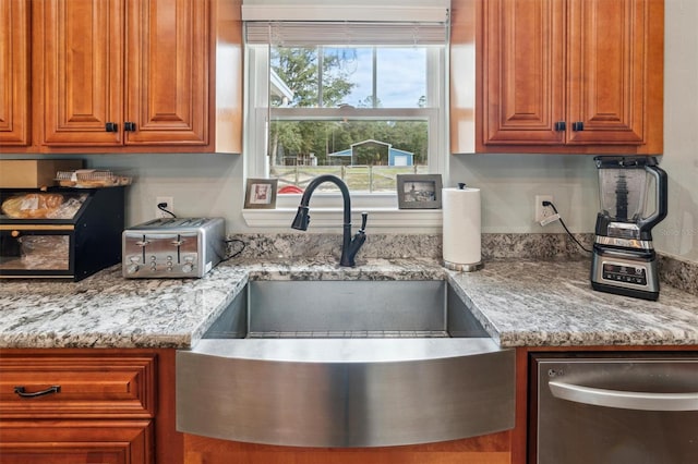 kitchen with sink, light stone counters, and dishwasher