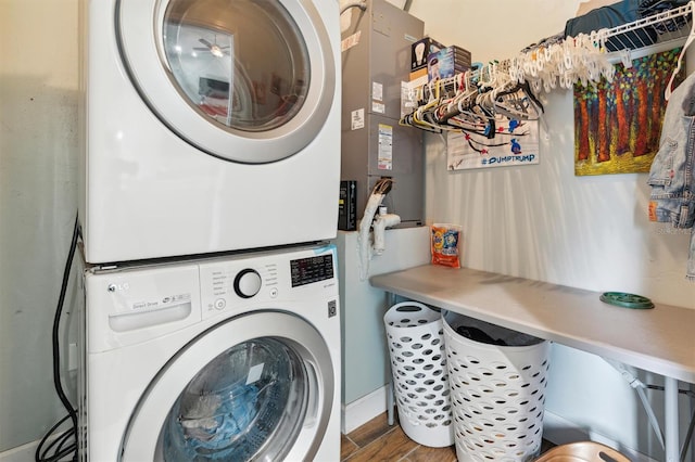 laundry room featuring stacked washer and clothes dryer and hardwood / wood-style floors