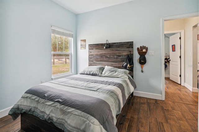 bedroom with dark hardwood / wood-style flooring