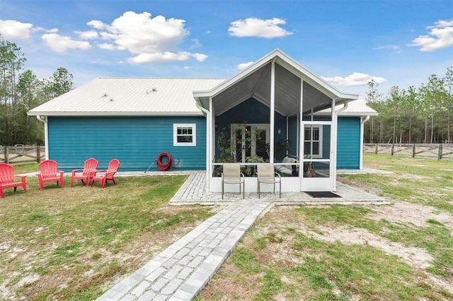 back of property with a yard and a sunroom