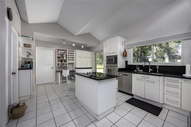 kitchen with stainless steel appliances, vaulted ceiling, white cabinets, sink, and a kitchen island