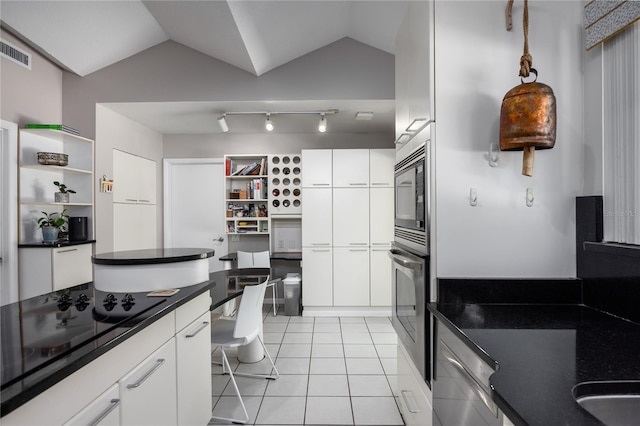 kitchen with white cabinetry, appliances with stainless steel finishes, and lofted ceiling