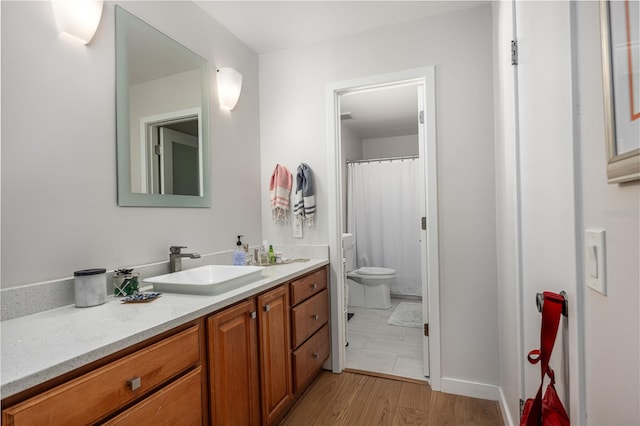 bathroom featuring vanity, hardwood / wood-style flooring, and toilet