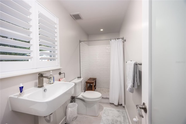 bathroom with curtained shower, sink, and toilet