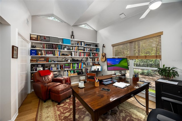 home office featuring hardwood / wood-style floors, ceiling fan, and vaulted ceiling