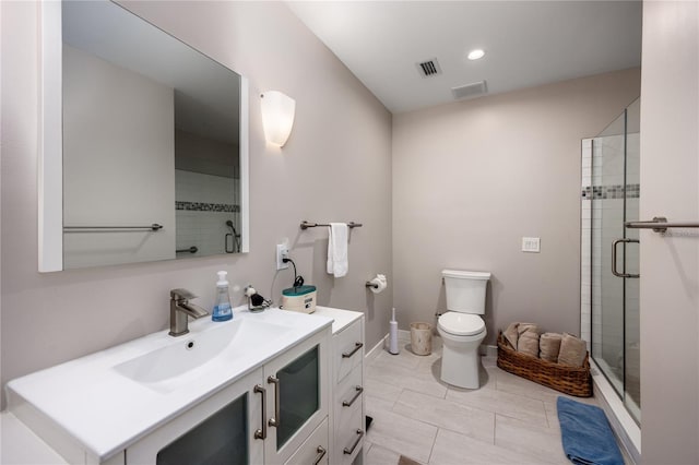 bathroom with a shower with shower door, vanity, and toilet