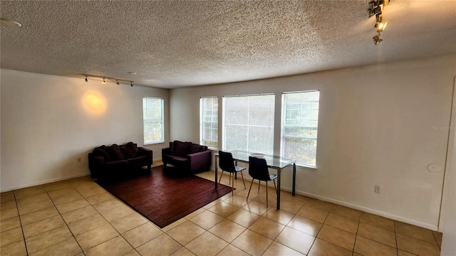 tiled living room with rail lighting and a textured ceiling