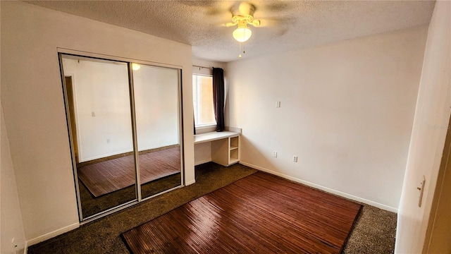 unfurnished bedroom with hardwood / wood-style floors, a closet, a textured ceiling, and ceiling fan