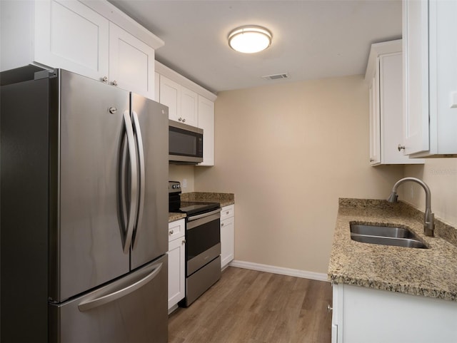 kitchen with sink, appliances with stainless steel finishes, and white cabinets