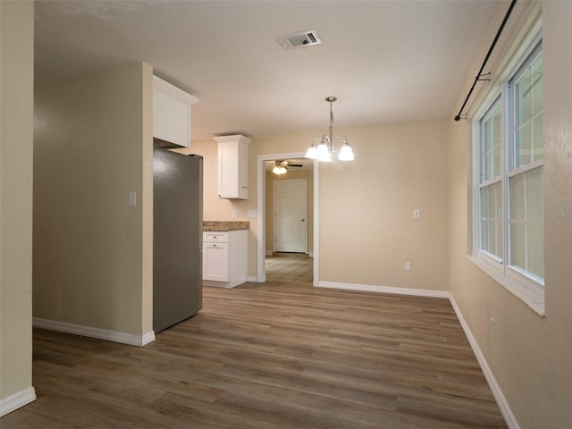 kitchen featuring stainless steel fridge, white cabinets, and dark hardwood / wood-style floors