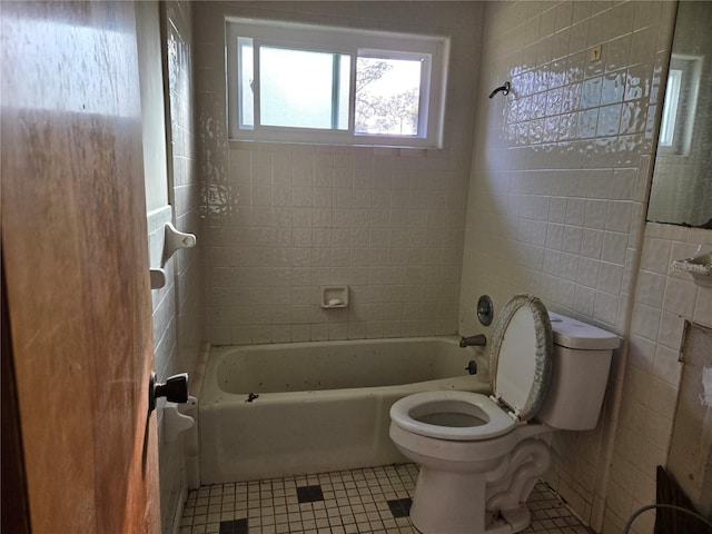 bathroom featuring toilet, tile walls, and tile patterned floors