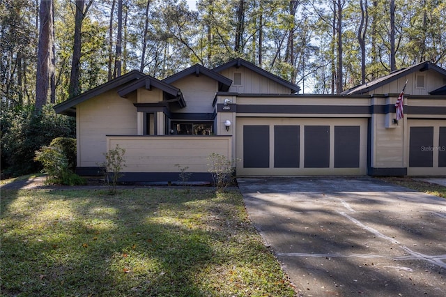 view of front of home with a front yard, board and batten siding, concrete driveway, and an attached garage