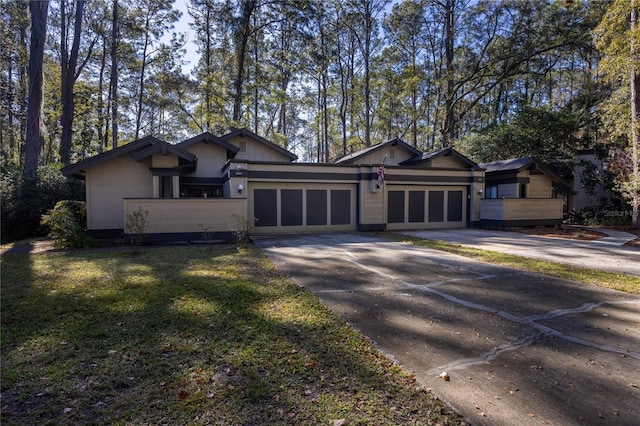 view of front facade with a front lawn, an attached garage, and driveway