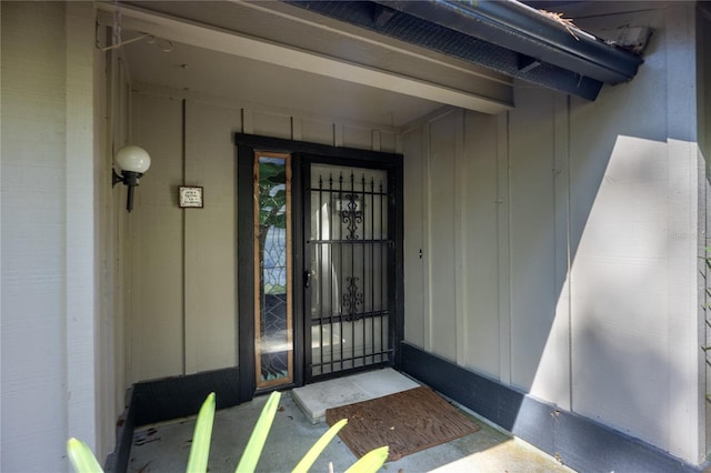 property entrance with board and batten siding and brick siding